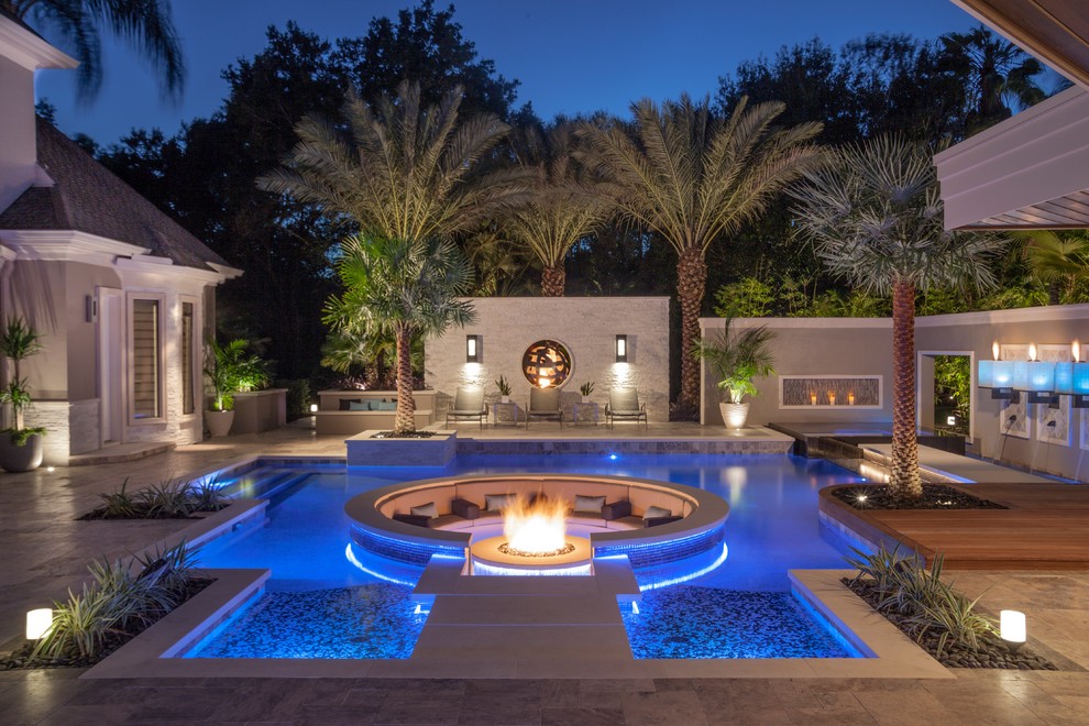 Foto di una grande piscina minimalista personalizzata dietro casa con pavimentazioni in pietra naturale