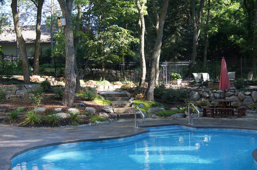 Modelo de piscina elevada de estilo americano de tamaño medio a medida en patio con suelo de hormigón estampado
