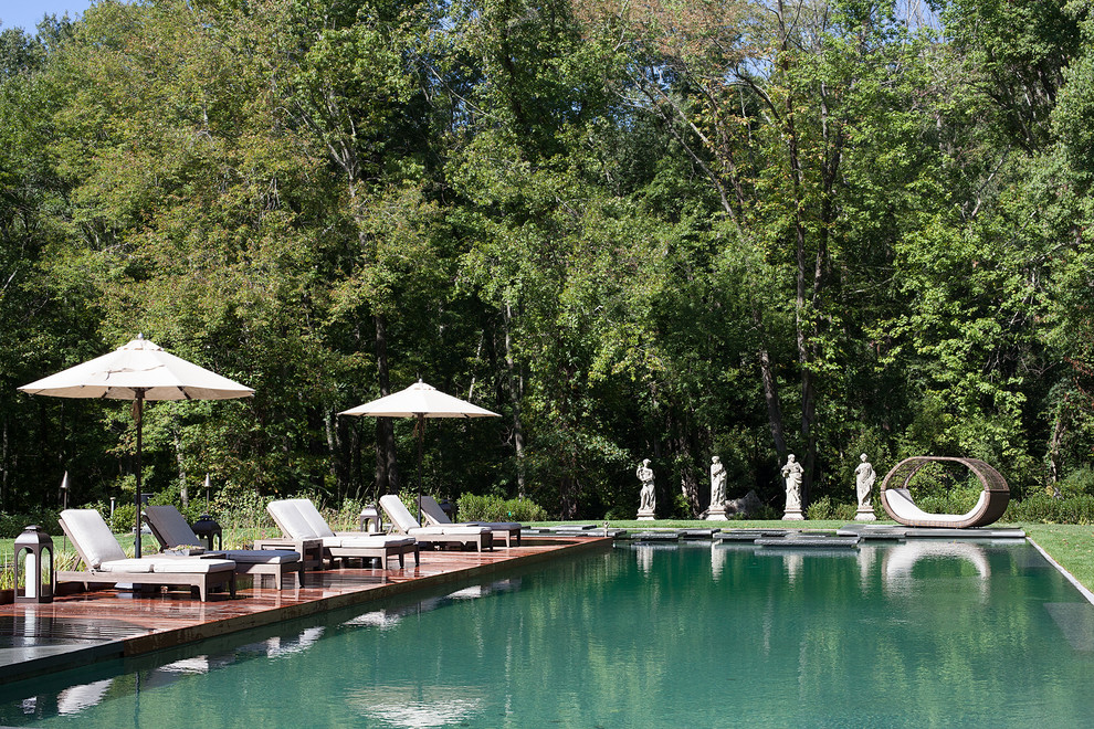 Ejemplo de piscina con fuente natural clásica renovada grande rectangular en patio trasero con adoquines de piedra natural