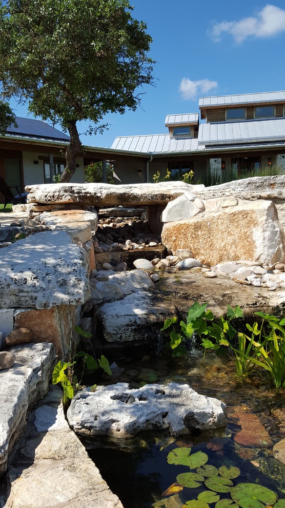 Diseño de piscina con fuente natural mediterránea a medida en patio delantero