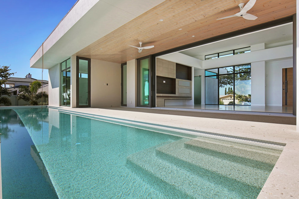 Ispirazione per una piscina monocorsia minimal rettangolare di medie dimensioni e dietro casa con pavimentazioni in cemento