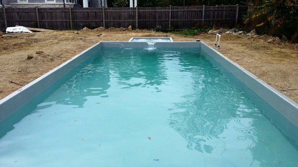 Cette image montre une piscine naturelle et arrière minimaliste de taille moyenne et rectangle avec un bain bouillonnant et des pavés en brique.
