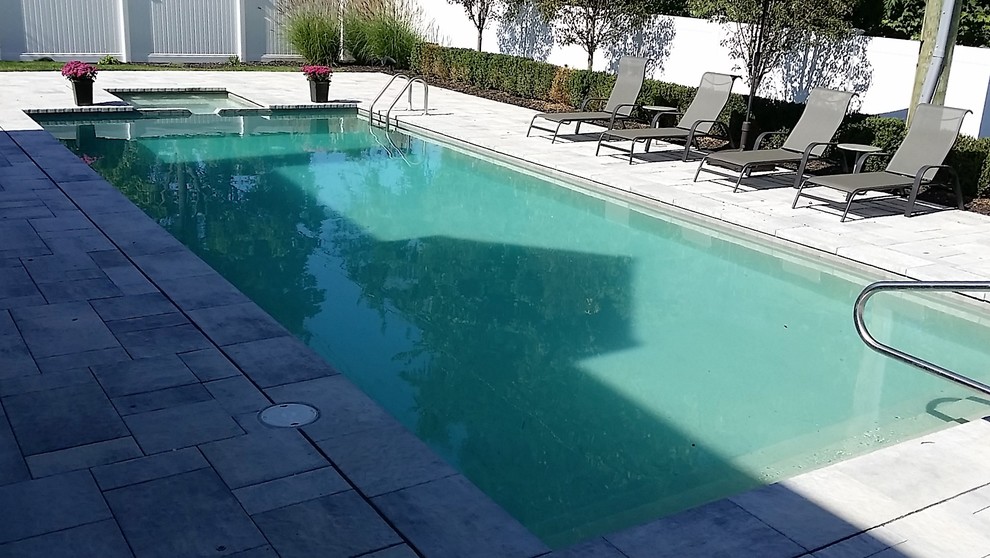 Foto di una piscina naturale minimalista rettangolare di medie dimensioni e dietro casa con una vasca idromassaggio e pavimentazioni in mattoni
