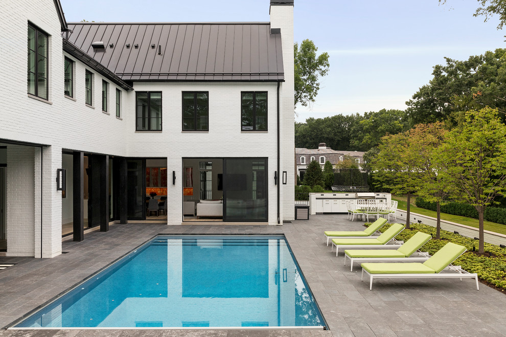 Idéer för en mycket stor modern pool på baksidan av huset, med naturstensplattor