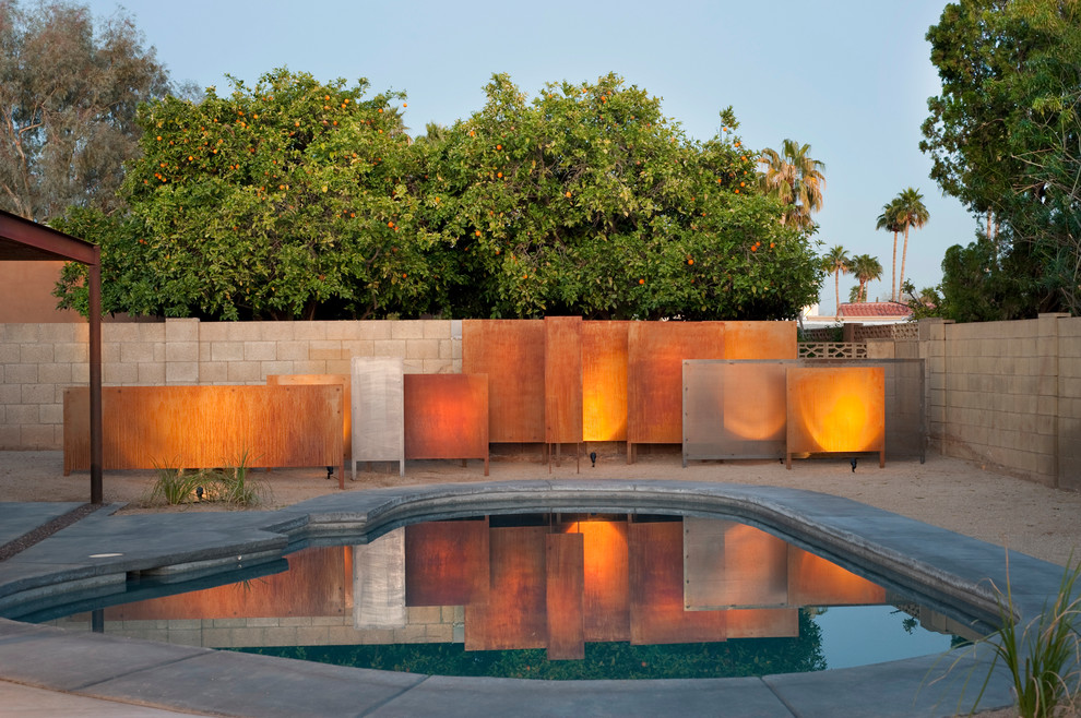 Идея дизайна: бассейн произвольной формы в стиле фьюжн с покрытием из бетонных плит