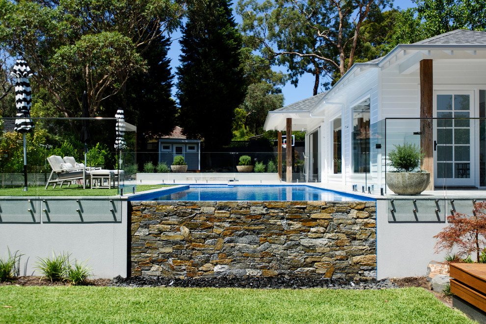 Esempio di una piscina a sfioro infinito contemporanea rettangolare di medie dimensioni e dietro casa con pavimentazioni in cemento