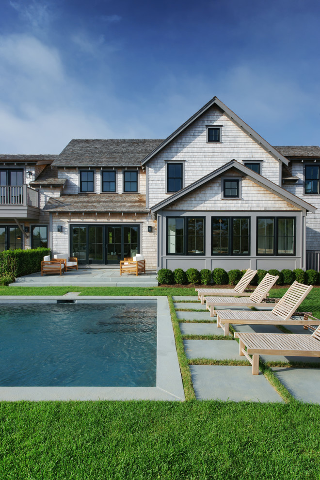 Country Pool hinter dem Haus in rechteckiger Form mit Natursteinplatten in Boston