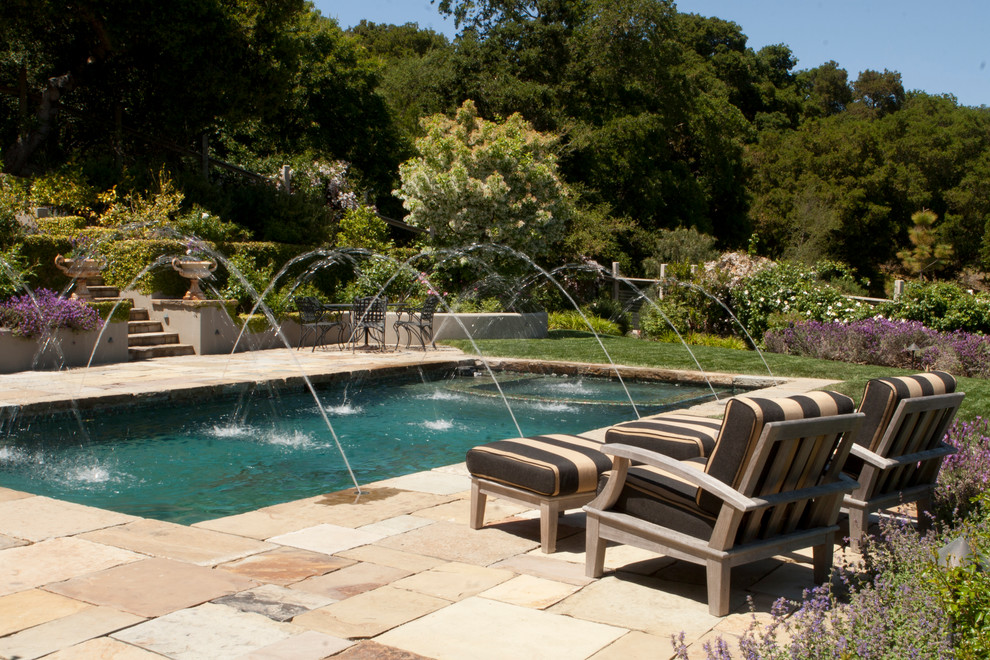 Idee per una grande piscina monocorsia classica rettangolare dietro casa con fontane e pavimentazioni in pietra naturale