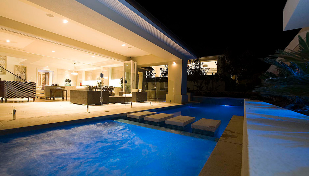 Pool - modern backyard concrete paver and custom-shaped pool idea in Melbourne