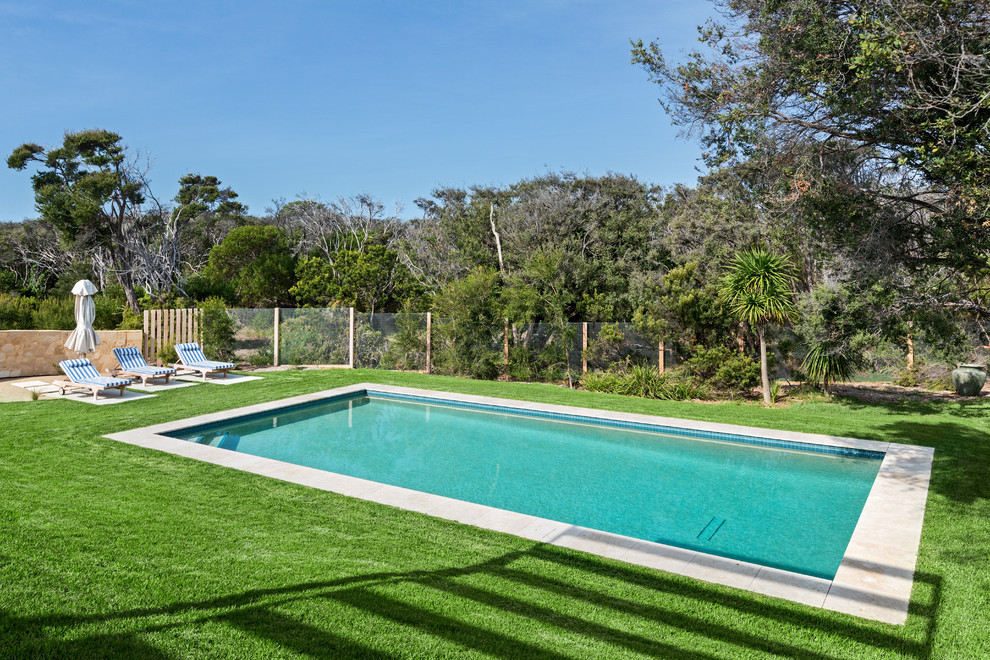 Пример оригинального дизайна: большой прямоугольный бассейн на заднем дворе в классическом стиле с покрытием из каменной брусчатки
