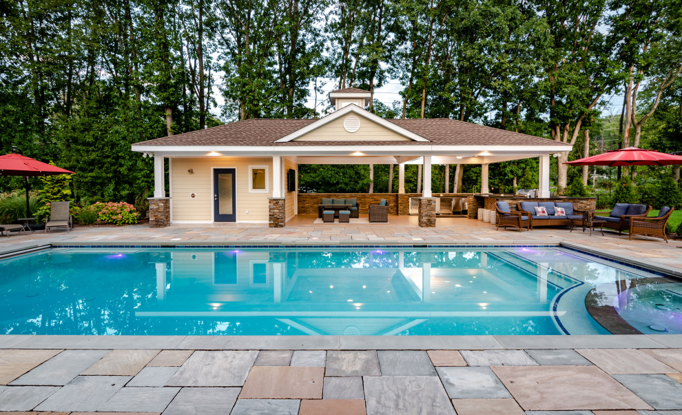 Ejemplo de casa de la piscina y piscina costera grande rectangular en patio trasero con adoquines de piedra natural