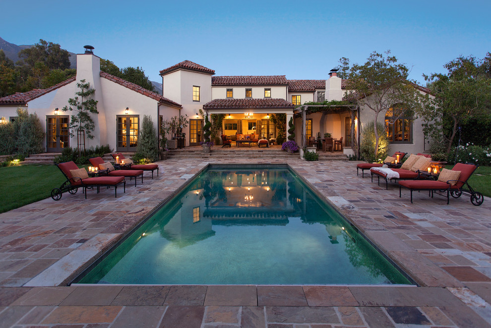 Mediterraner Pool hinter dem Haus in rechteckiger Form mit Natursteinplatten in Santa Barbara