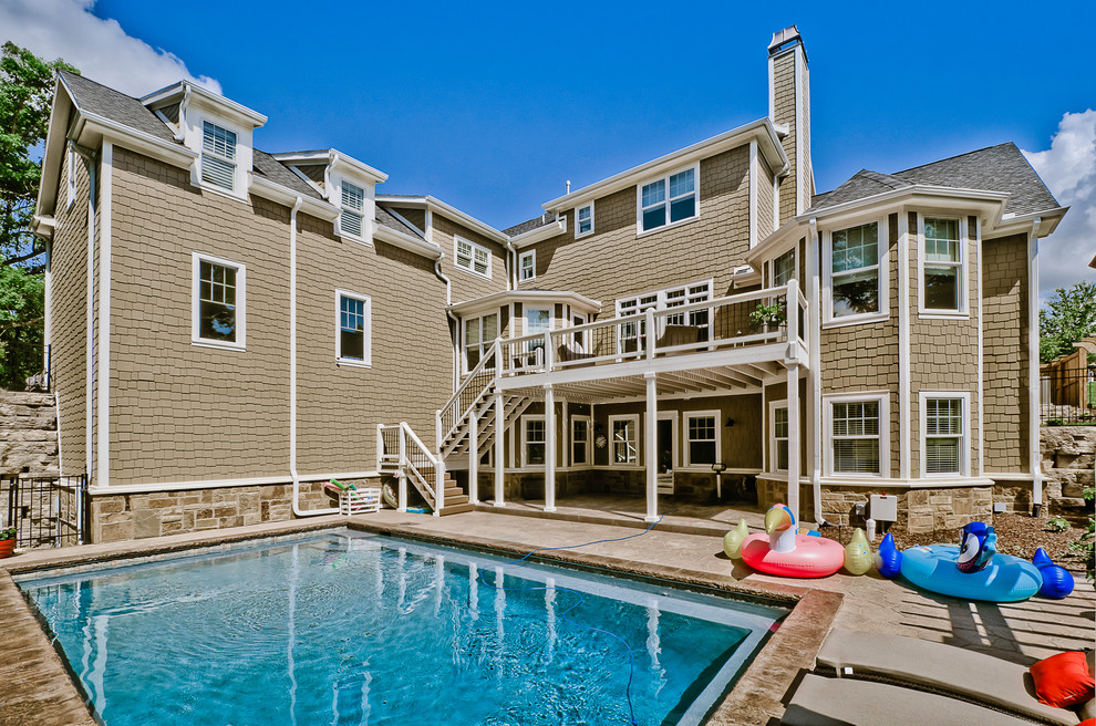 Imagen de piscina de estilo americano grande rectangular en patio trasero con suelo de hormigón estampado