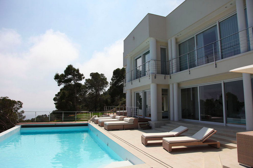Idee per una grande piscina monocorsia design rettangolare dietro casa con piastrelle