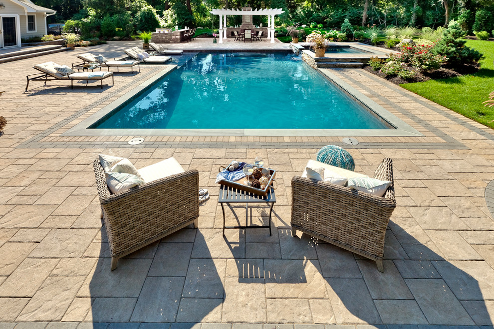 Modelo de piscina infinita minimalista extra grande a medida en patio trasero con adoquines de hormigón