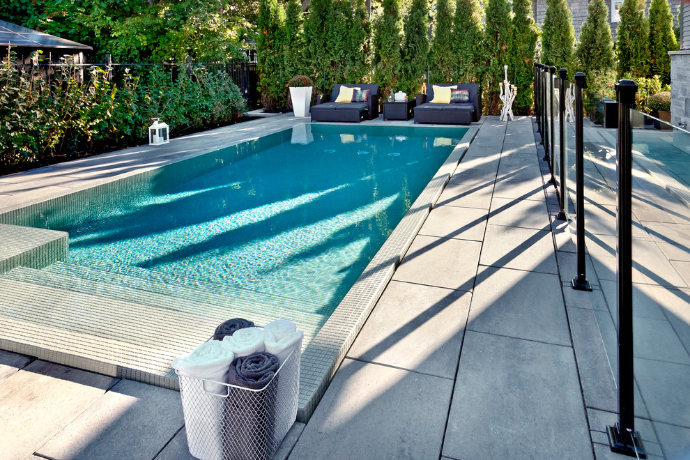 Example of a mid-sized minimalist backyard concrete and rectangular lap pool design in Philadelphia