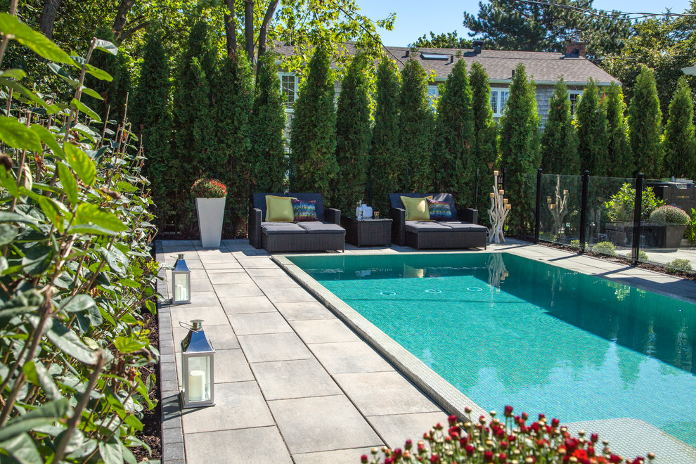 Esempio di una piscina monocorsia moderna rettangolare di medie dimensioni e dietro casa con lastre di cemento