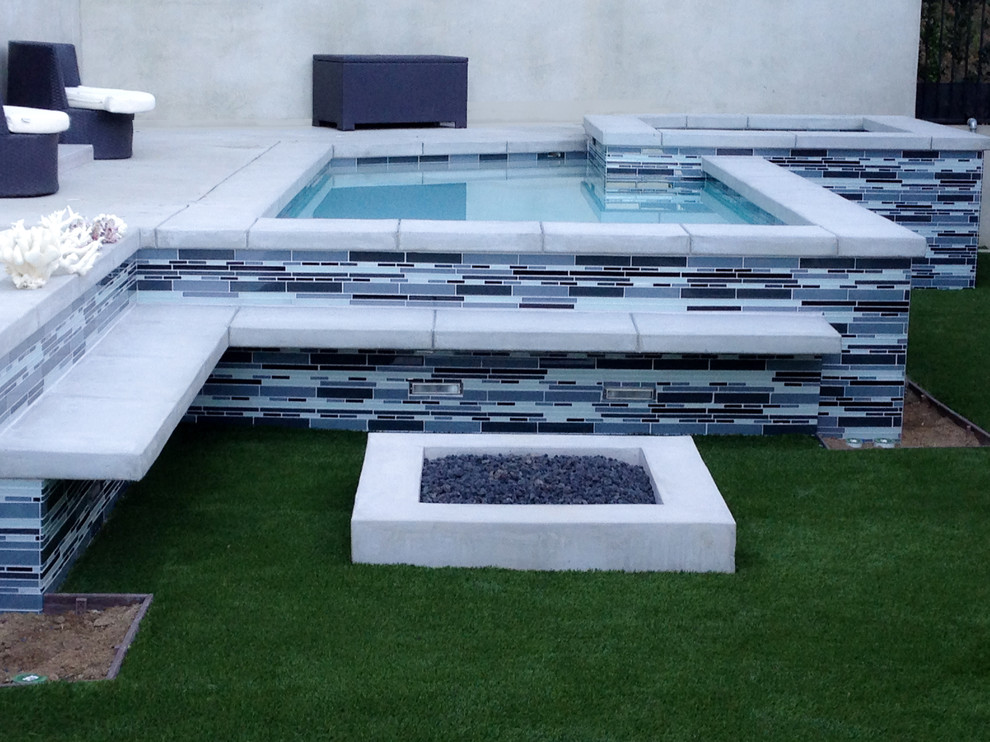 На фото: маленький наземный бассейн произвольной формы на заднем дворе в стиле модернизм с джакузи и покрытием из плитки для на участке и в саду с