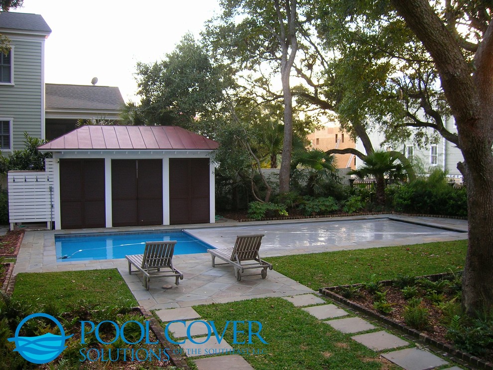 Aménagement d'une piscine naturelle classique de taille moyenne et rectangle avec une cour et des pavés en pierre naturelle.