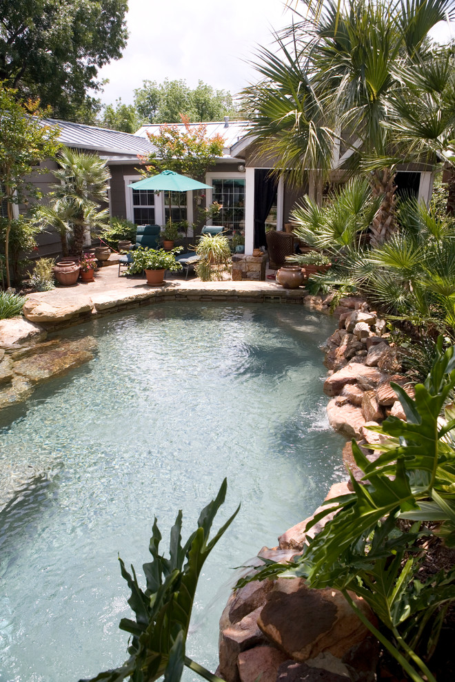 Foto de piscina natural rural pequeña a medida en patio trasero con adoquines de piedra natural