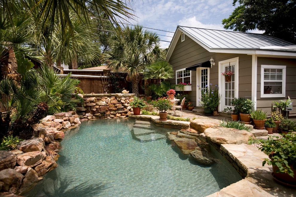 Imagen de piscina natural rural pequeña a medida en patio trasero con adoquines de piedra natural