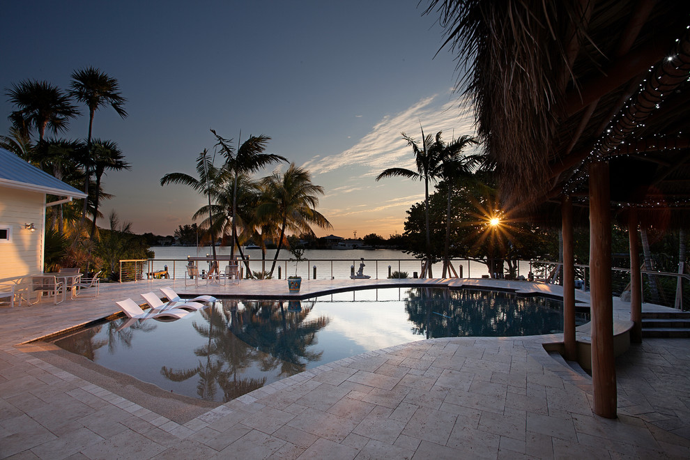 Diseño de casa de la piscina y piscina exótica de tamaño medio a medida en patio trasero con adoquines de piedra natural