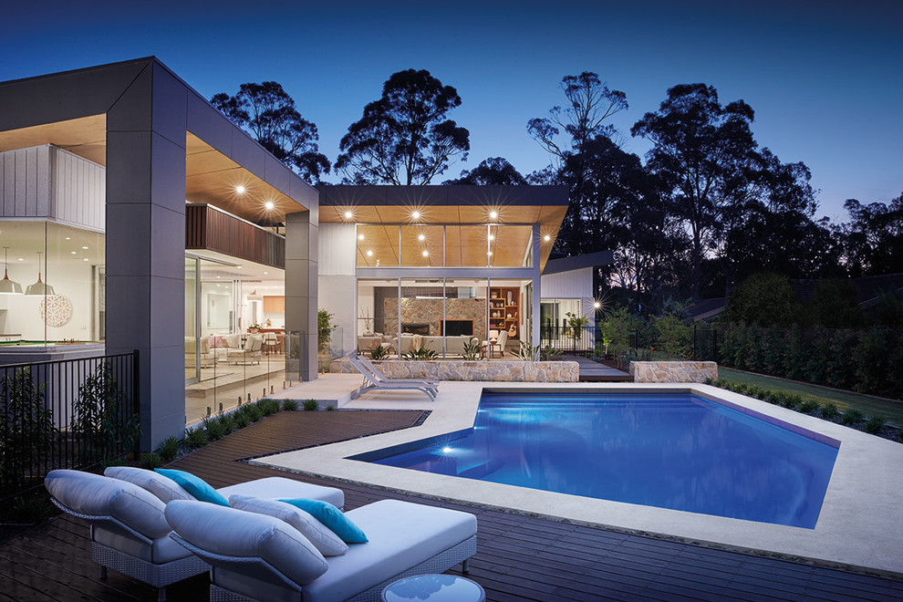 Aménagement d'une piscine à débordement et arrière contemporaine de taille moyenne et sur mesure avec une terrasse en bois.