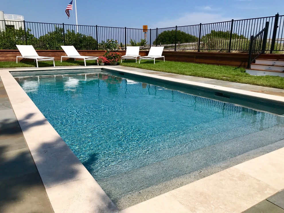 Foto de piscina alargada costera de tamaño medio rectangular en patio trasero con adoquines de piedra natural