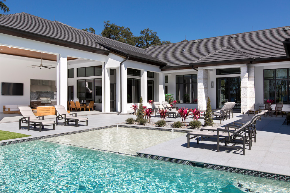 Large trendy backyard concrete paver and rectangular lap pool fountain photo in Orlando