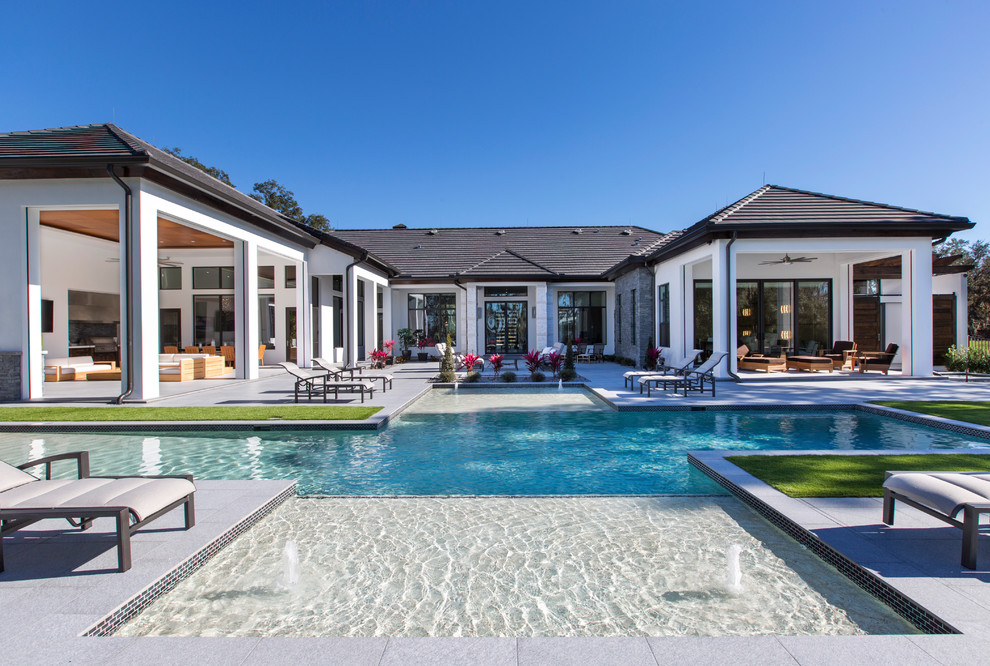 Großes Modernes Sportbecken hinter dem Haus in rechteckiger Form mit Wasserspiel und Betonboden in Orlando