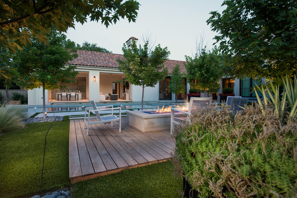 Foto de piscina infinita moderna grande rectangular en patio trasero con losas de hormigón
