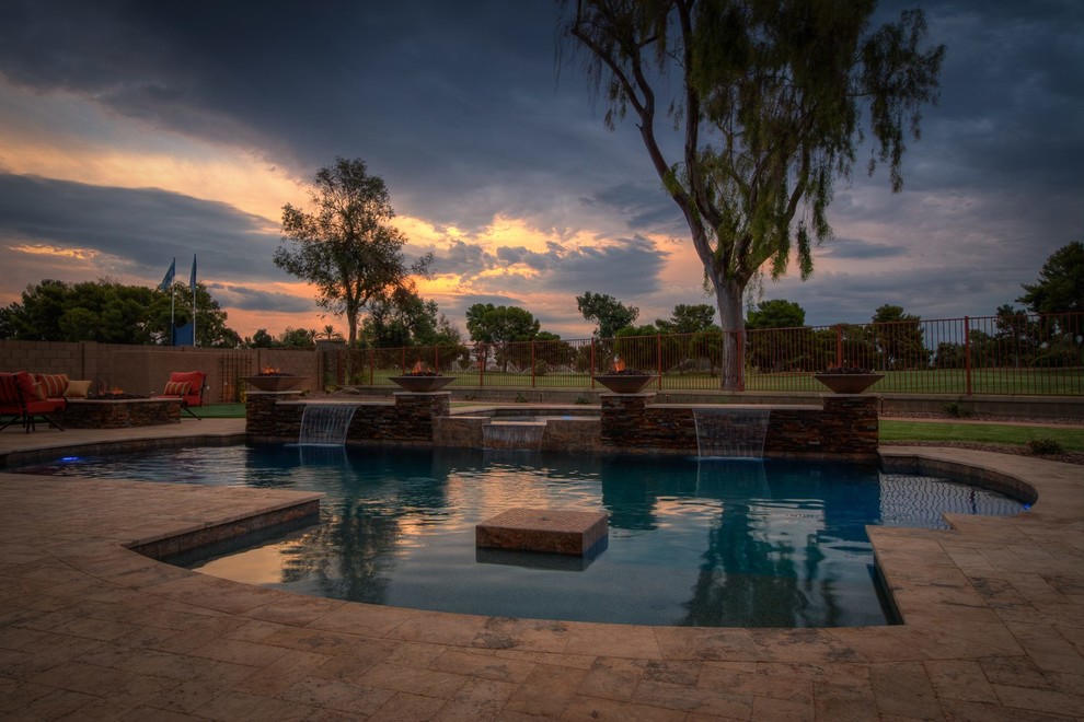 Ispirazione per una grande piscina naturale minimal personalizzata dietro casa con fontane e pavimentazioni in pietra naturale