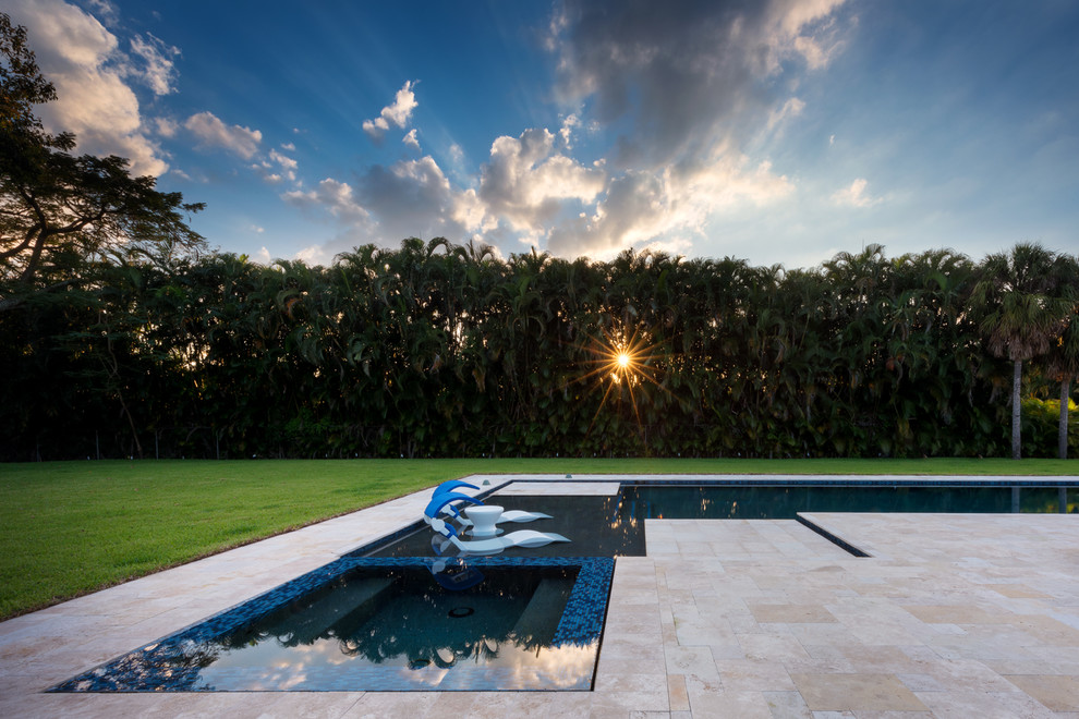 Großer Moderner Pool hinter dem Haus in L-Form mit Natursteinplatten in Miami