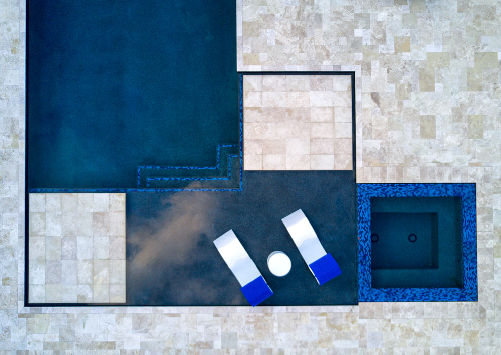 Ejemplo de piscinas y jacuzzis alargados minimalistas grandes en forma de L en patio trasero con adoquines de piedra natural