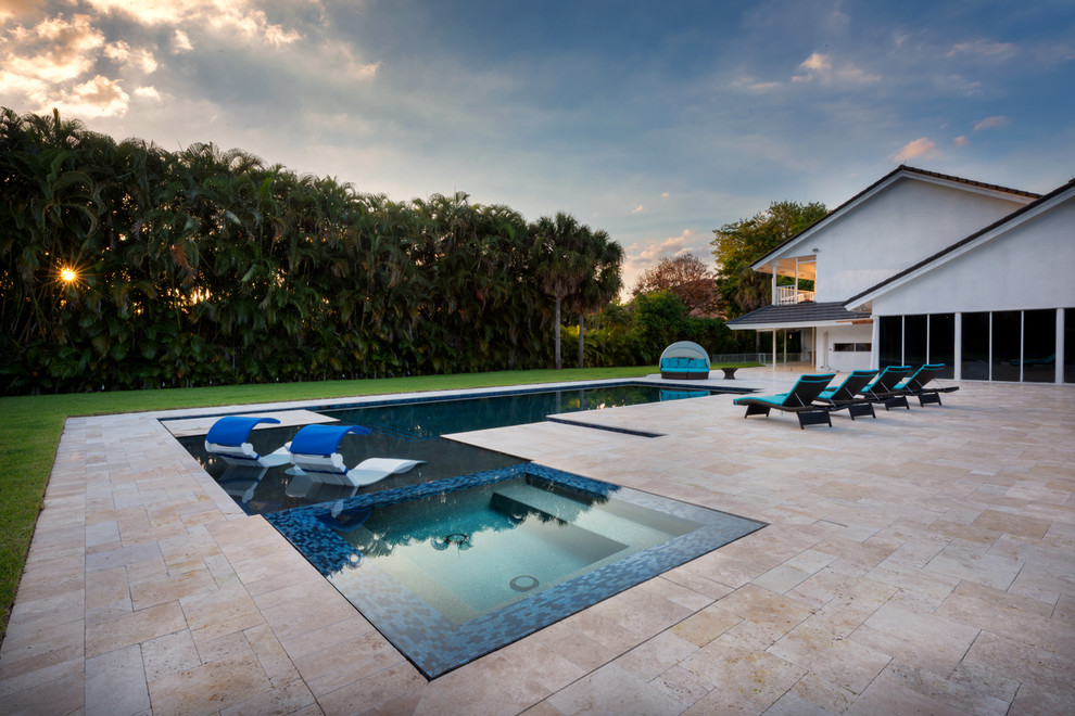 Idee per una grande piscina monocorsia moderna a "L" dietro casa con una vasca idromassaggio e pavimentazioni in pietra naturale