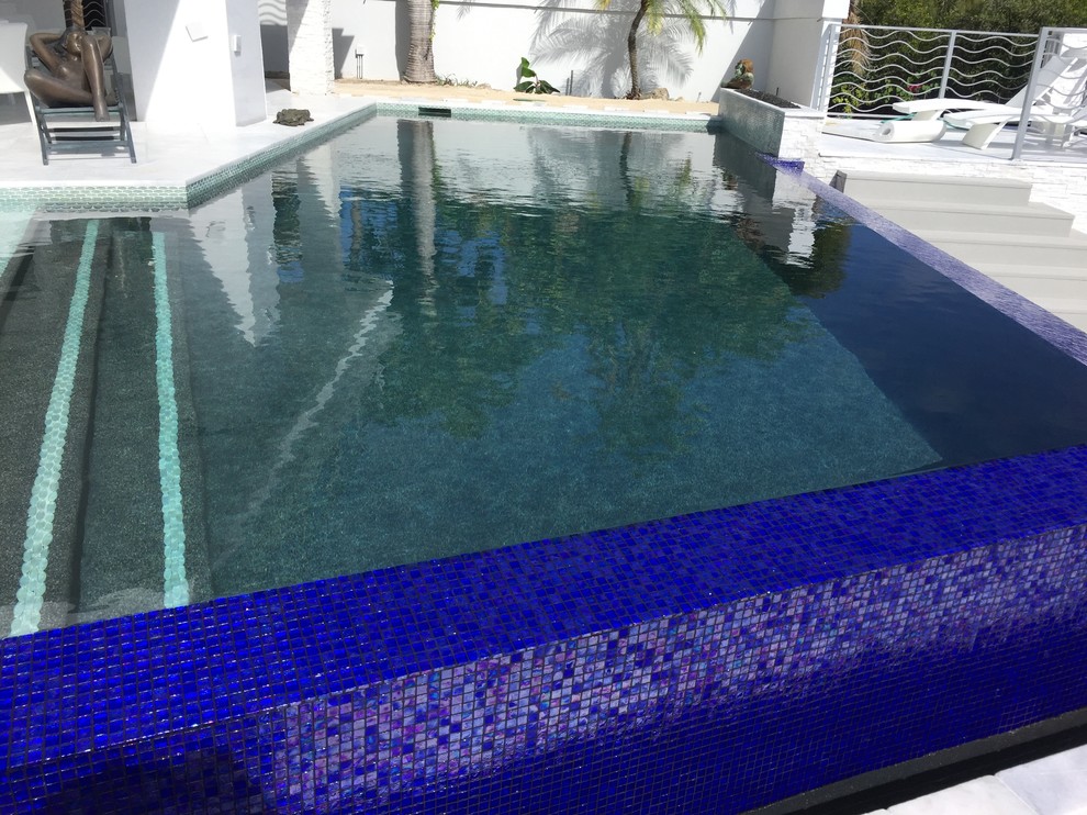 Idee per una piscina a sfioro infinito contemporanea personalizzata di medie dimensioni e dietro casa con fontane e piastrelle