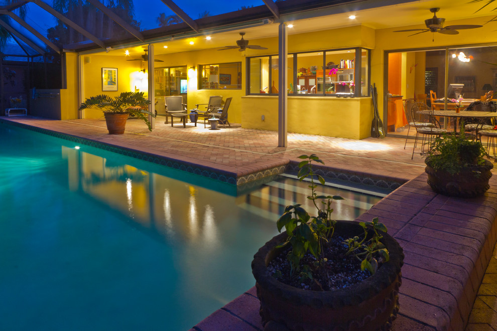 Großer Retro Pool hinter dem Haus in rechteckiger Form mit Pflastersteinen in Miami