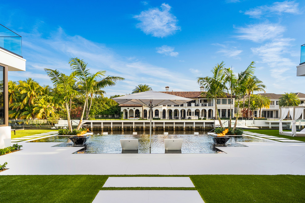 Ejemplo de piscinas y jacuzzis infinitos minimalistas grandes rectangulares en patio trasero con suelo de baldosas