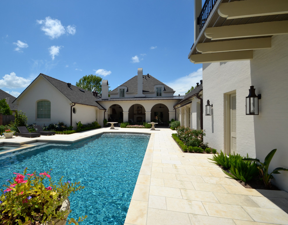 Modelo de piscinas y jacuzzis alargados eclécticos de tamaño medio a medida en patio trasero con adoquines de piedra natural