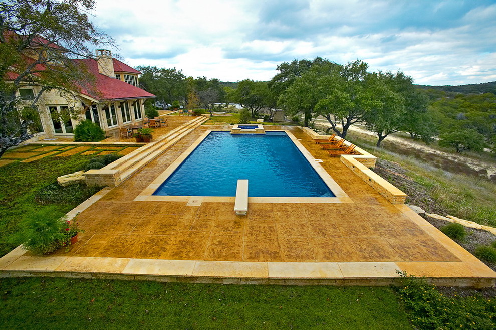 Foto de piscina alargada tradicional extra grande rectangular en patio trasero con losas de hormigón