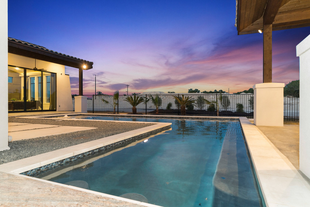 Diseño de piscina mediterránea grande a medida en patio trasero con privacidad y adoquines de ladrillo