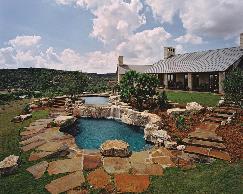 Huge mountain style backyard stone and custom-shaped natural pool fountain photo in Austin