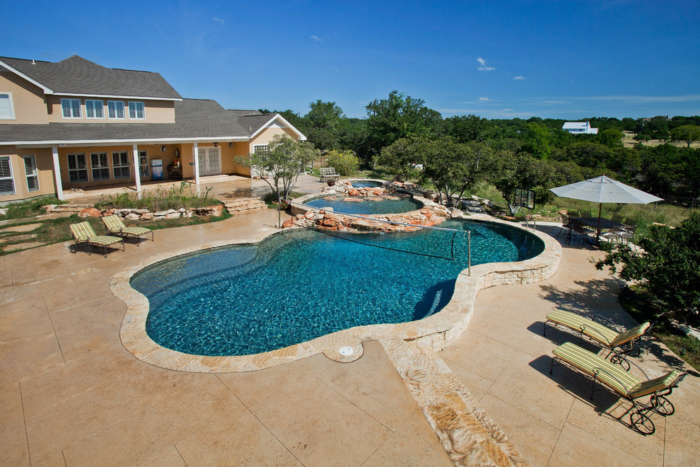Pool house - large rustic backyard concrete and custom-shaped natural pool house idea in Austin