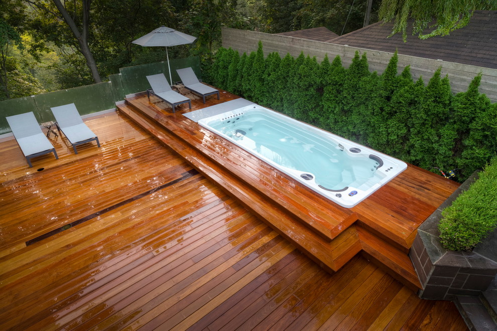 Immagine di una piccola piscina monocorsia moderna rettangolare dietro casa con una vasca idromassaggio e pedane