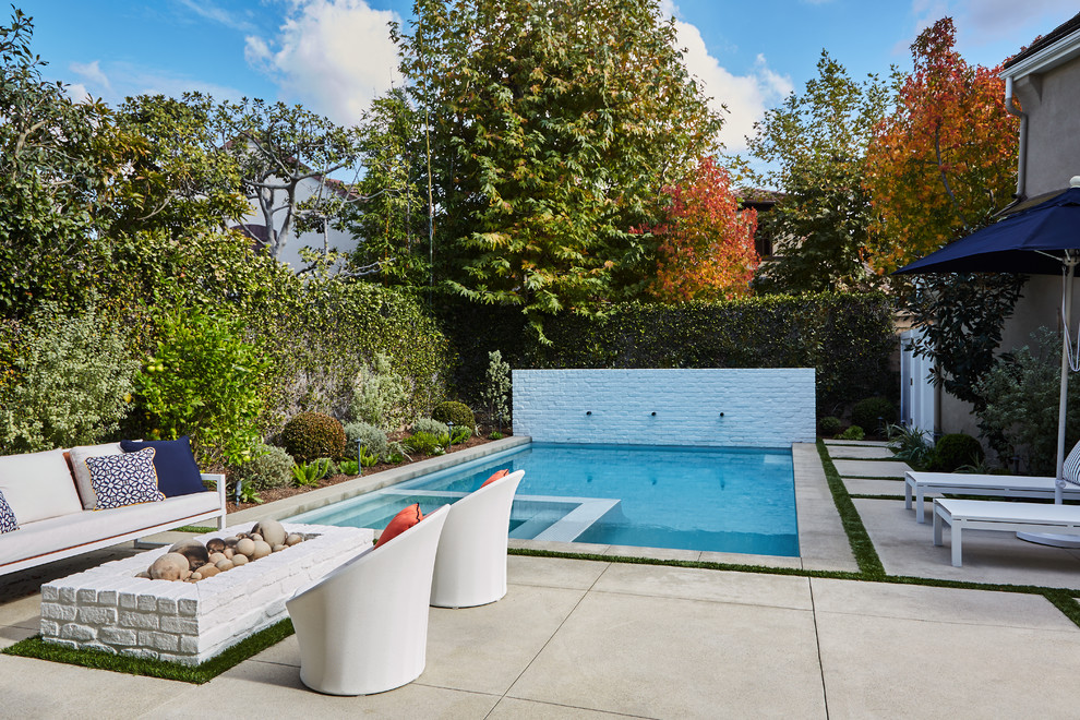 Пример оригинального дизайна: прямоугольный бассейн среднего размера на заднем дворе в современном стиле с фонтаном и мощением тротуарной плиткой