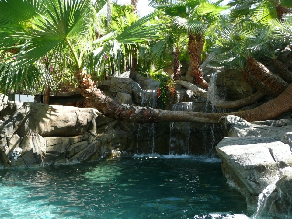 Ispirazione per una grande piscina naturale tropicale personalizzata dietro casa con cemento stampato e una vasca idromassaggio
