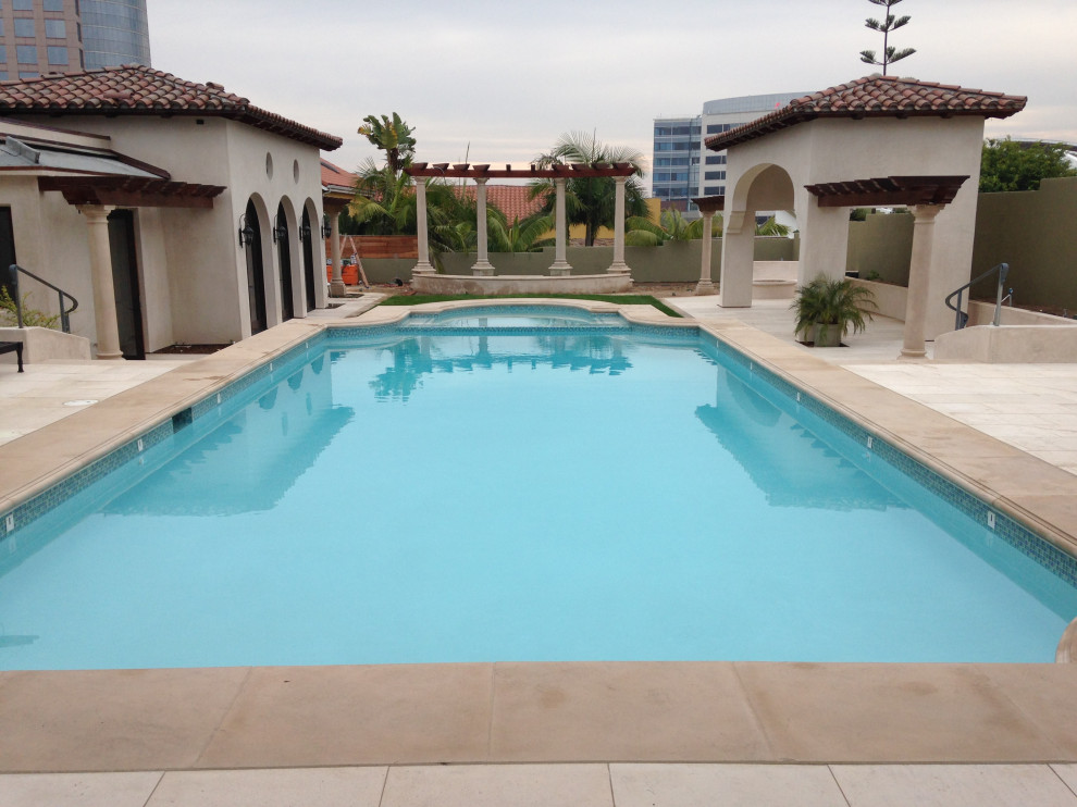 Ispirazione per una piscina mediterranea personalizzata di medie dimensioni e dietro casa con una vasca idromassaggio e lastre di cemento
