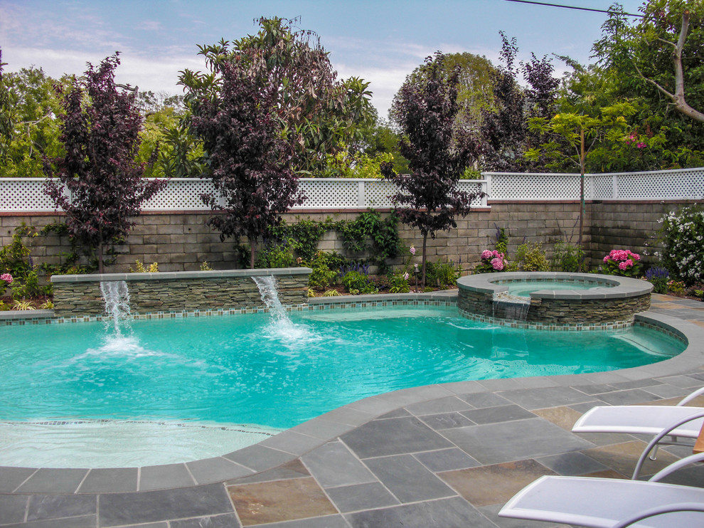 Свежая идея для дизайна: естественный бассейн среднего размера, в форме фасоли на заднем дворе в классическом стиле с джакузи и покрытием из каменной брусчатки - отличное фото интерьера