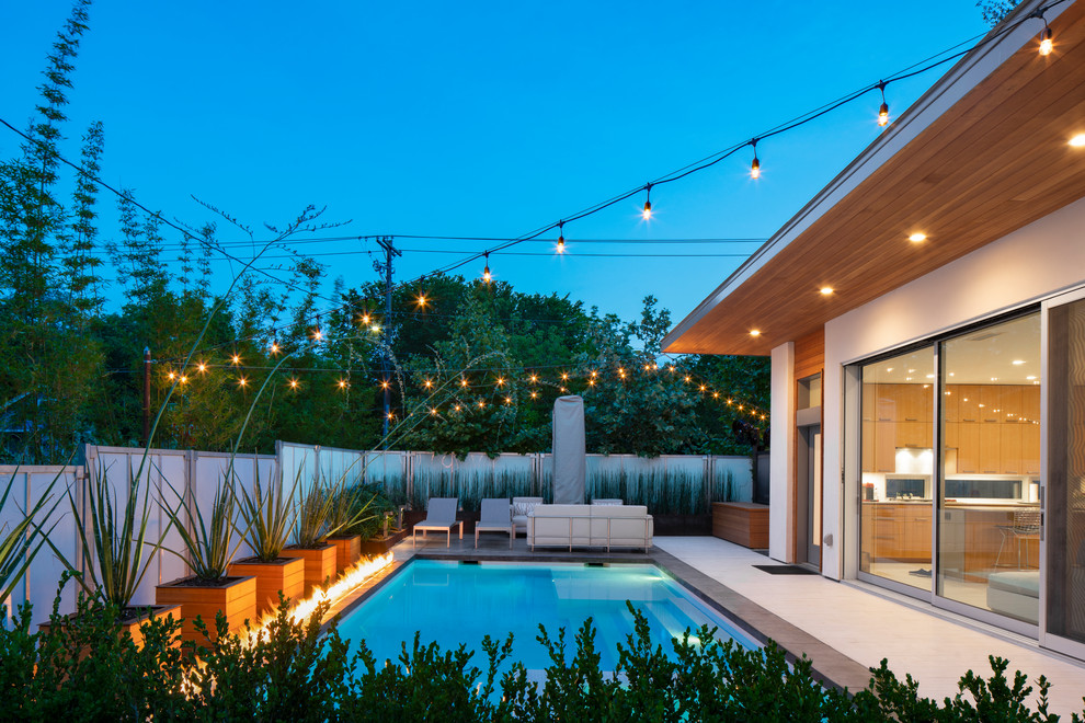 Ispirazione per una piscina minimalista rettangolare di medie dimensioni e in cortile con una vasca idromassaggio e pedane