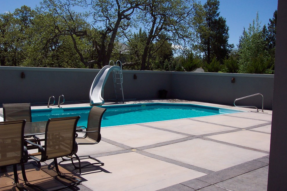 Inspiration pour une piscine arrière traditionnelle de taille moyenne et rectangle avec un toboggan et des pavés en pierre naturelle.